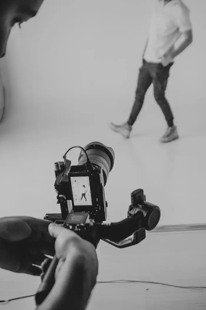 Cinematographer recording model in studio using DSLR camera and stabilizer.