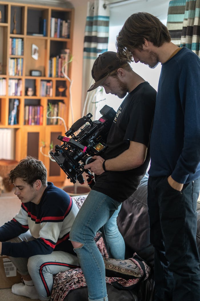Young filmmakers collaborating on a project indoors with camera equipment.